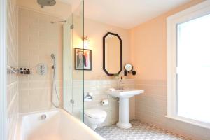 a bathroom with a tub and a sink and a toilet at The Grand Hotel Birmingham in Birmingham