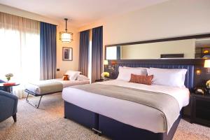 a hotel room with a large bed and a chair at The Grand Hotel Birmingham in Birmingham