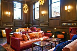a living room with a couch and tables and windows at The Grand Hotel Birmingham in Birmingham