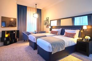 a hotel room with two beds and a desk at The Grand Hotel Birmingham in Birmingham