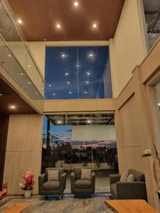 a lobby with two chairs and a large window at Grand Samota Hotel in Sumbawa Besar