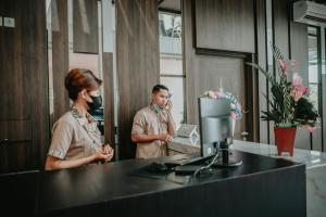 Ein Mann und eine Frau in einem Zimmer mit Maske. in der Unterkunft Grand Samota Hotel in Sumbawa Besar