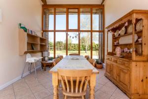 a dining room with a table and a large window at Bridge Farm Holiday Cottages in Cow Honeybourne +33 photos