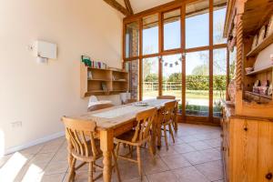 a dining room with a wooden table and chairs at Bridge Farm Holiday Cottages in Cow Honeybourne
