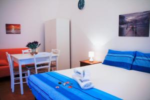 ein Schlafzimmer mit einem Bett und einem Tisch mit einem Stuhl in der Unterkunft Complesso Giuliano by TerraSalento in Giuliano + 14 Fotos