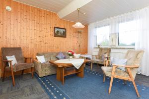 a living room with a couch and a table and chairs at Ferienwohnungen im Haus Beluga in Bensersiel
