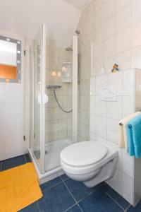 a bathroom with a shower with a toilet and a sink at Ferienwohnungen im Haus Beluga in Bensersiel