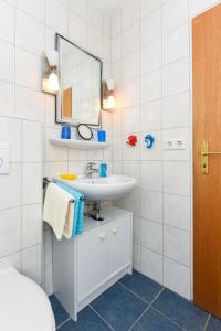 a bathroom with a sink and a mirror at Ferienwohnungen im Haus Beluga in Bensersiel