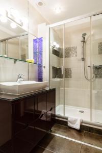uma casa de banho com um lavatório e um chuveiro em Victus Apartamenty, Apartament Biały Piasek em Sopot