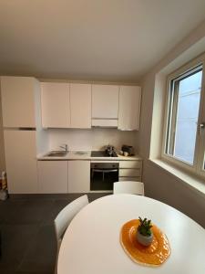 una cucina con tavolo bianco e piano di lavoro bianco di M8tto ad Arco Altre 2 foto