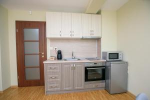 a kitchen with white cabinets and a sink and a microwave at Feel at Home in Sandanski