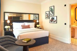 a bedroom with a bed and a chair and a table at The Grand Hotel Birmingham in Birmingham