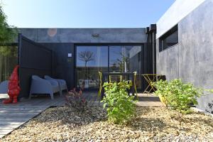 Le jardin de Séverine في شالون سور سون: منزل به فناء مع كراسي ونباتات