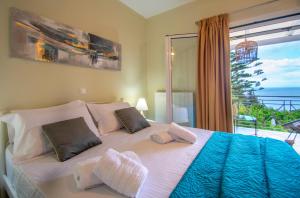 a bedroom with a bed with a view of the ocean at Alavastros Maisonettes Near 3 sandy beaches in Vasilikos