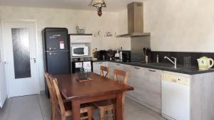 cocina con mesa de madera y nevera en Gîte de La Saugiat en Le Fied