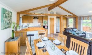 a kitchen and living room with a table and chairs at Sheffield Pike Lodge in Windermere