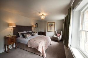 a bedroom with a bed and a chair and a window at The Ickworth Hotel And Apartments - A Luxury Family Hotel in Bury Saint Edmunds