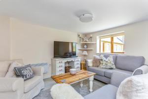 a living room with two couches and a tv at Bridge Farm Holiday Cottages in Cow Honeybourne