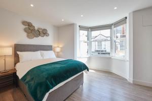 a bedroom with a large bed and two windows at Host & Stay - The Merchants Quarters in Scarborough