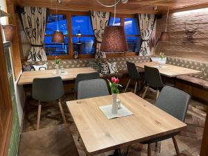 ガルゲレンにあるHotel Alpenroseの木製のテーブルと椅子、窓のあるレストラン
