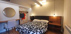 una camera con letto bianco e nero e specchio di Apartamento EL PILAR Céntrico, ascensor, cocina, a Saragozza