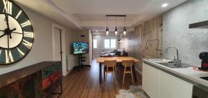 a kitchen with a table and a large clock on the wall at Apartamento EL PILAR Céntrico ascensor cocina WIFI en Zaragoza by lodom in Zaragoza