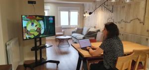 una mujer sentada en una mesa jugando un videojuego en Apartamento EL PILAR Céntrico ascensor cocina WIFI en Zaragoza by lodom, en Zaragoza