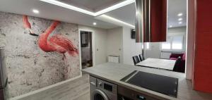a kitchen with a pink flamingo painting on the wall at Apartamento NATURA Céntrico ascensor cocina WIFI en Zaragoza by lodom in Zaragoza