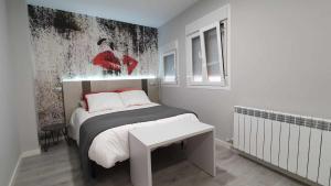 a small bedroom with a bed with a black and white bedspread at Apartamento NATURA Céntrico ascensor cocina WIFI en Zaragoza by lodom in Zaragoza