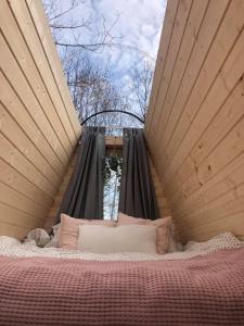 a bed with two pillows on it in a room at Niiralan Tila : Starlite Cabin in Laitila