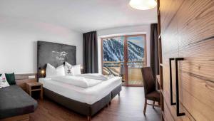 una camera d'albergo con letto e finestra di Berghotel & Gasthof Marlstein a Oetz