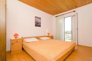a bedroom with a bed and a large window at Apartments Sutvid in Drače