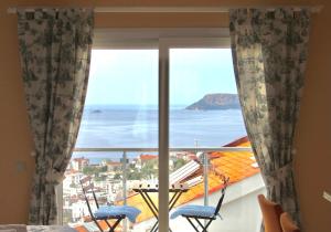 Cette chambre dispose d'une grande fenêtre offrant une vue sur l'océan. dans l'établissement Saylam Suites, à Kaş