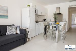 eine Küche und ein Wohnzimmer mit einer Couch und einem Tisch in der Unterkunft YourHouse Es Niu, apartment in Puerto de Sóller in Sóller