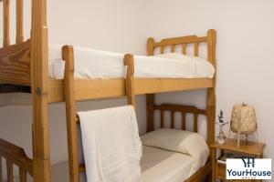 2 Etagenbetten in einem Zimmer mit einem Handtuch in der Unterkunft YourHouse Es Niu, apartment in Puerto de Sóller in Sóller