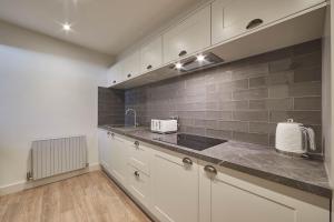 a kitchen with white cabinets and a sink at Host & Stay - The Merchants Quarters in Scarborough