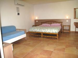 1 dormitorio con 1 cama y 1 sofá en Baia degli ulivi, en Diamante