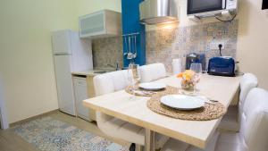 セビリアにあるDeluxe Apartment in La Giraldaのキッチン(木製テーブル、白い椅子付)