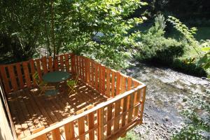 a wooden fence with a table and a chair at Logis Hôtel Andreinia & Cabanes in Esterençuby