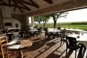 a restaurant with tables and chairs and a large window at CRAMA APOGEUM - Adult only in Gura Vadului