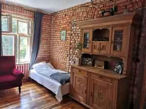 a bedroom with a bed and a brick wall at Agroturystyka Gęsiniec Stare Osieczno in Stare Osieczno