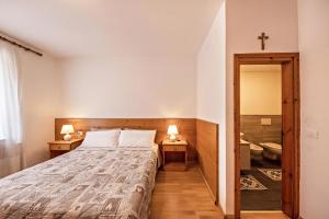 a bedroom with a bed and a cross on the wall at Appartamento Primavera 2 in Moena