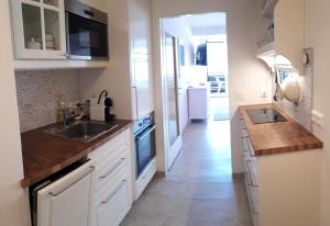 a kitchen with white cabinets and a sink at JOHANNES Seeblick Appartement im Haus Hänsel Gretel direkt am Ossiachersee in Stiegl