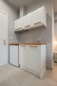 a kitchen with white cabinets and a white refrigerator at Armonia Rooms in Myrina