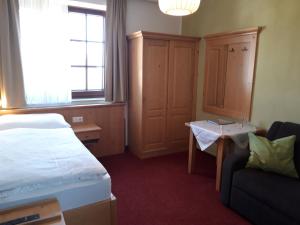 a bedroom with a bed and a chair and a window at Haus Maria Holzöster in Franking