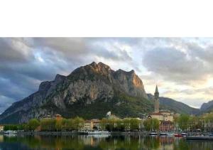 a mountain in front of a city and a body of water at La nostra casa in centro in Lecco
