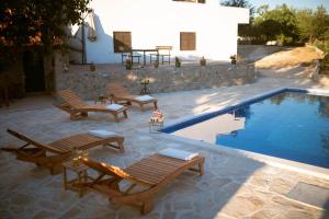 a pool with chaise lounge chairs and a swimming pool at Holiday Home Pearl in Stone with Heated Pool in Imotski