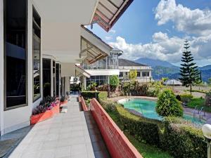 an exterior view of a house with a swimming pool at OYO 90028 Hotel Victory in Batu