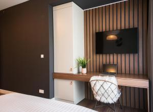 a bedroom with a desk with a laptop and a tv at Biador Apartments in Oradea