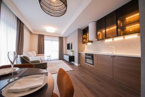 cocina y sala de estar con mesa y sillas en Biador Apartments, en Oradea